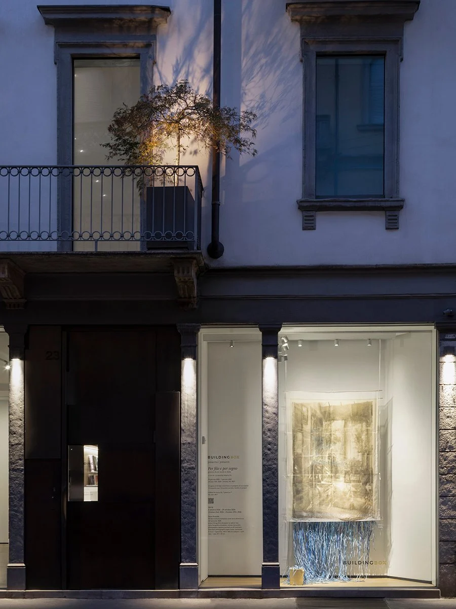 Dario Picariello’s textile work visible through the street-facing BUILDING BOX window at dusk.