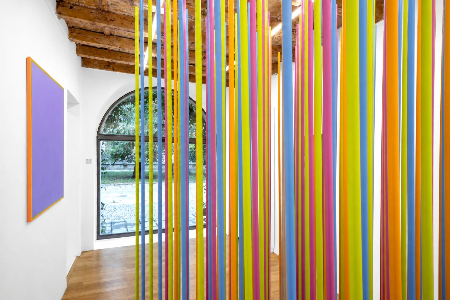 Long, brightly coloured vertical elements fill a gallery space in Jorrit Tornquist’s exhibition.